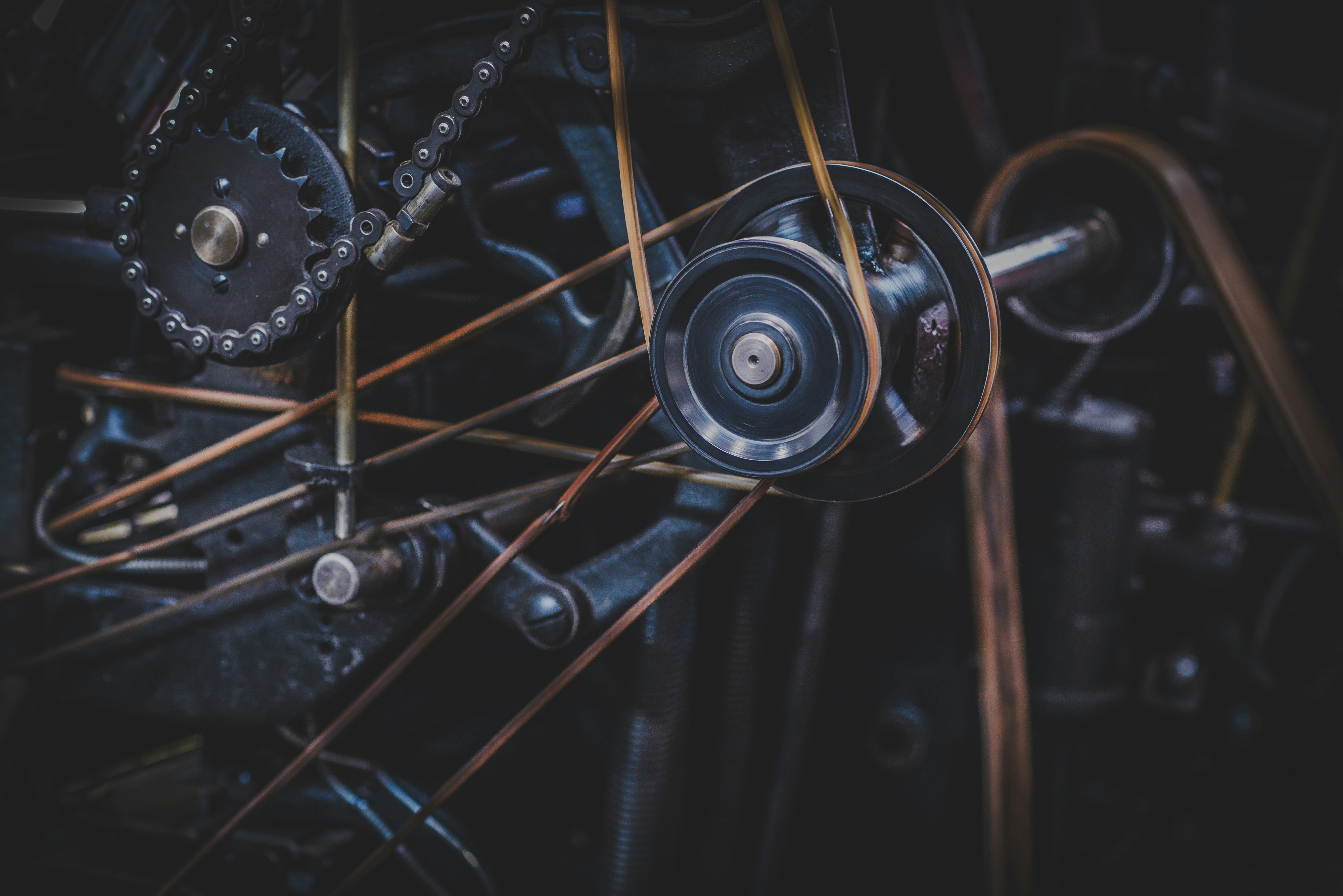 Close-up of industrial machinery with interlocking gears, chains, belts, and pulleys