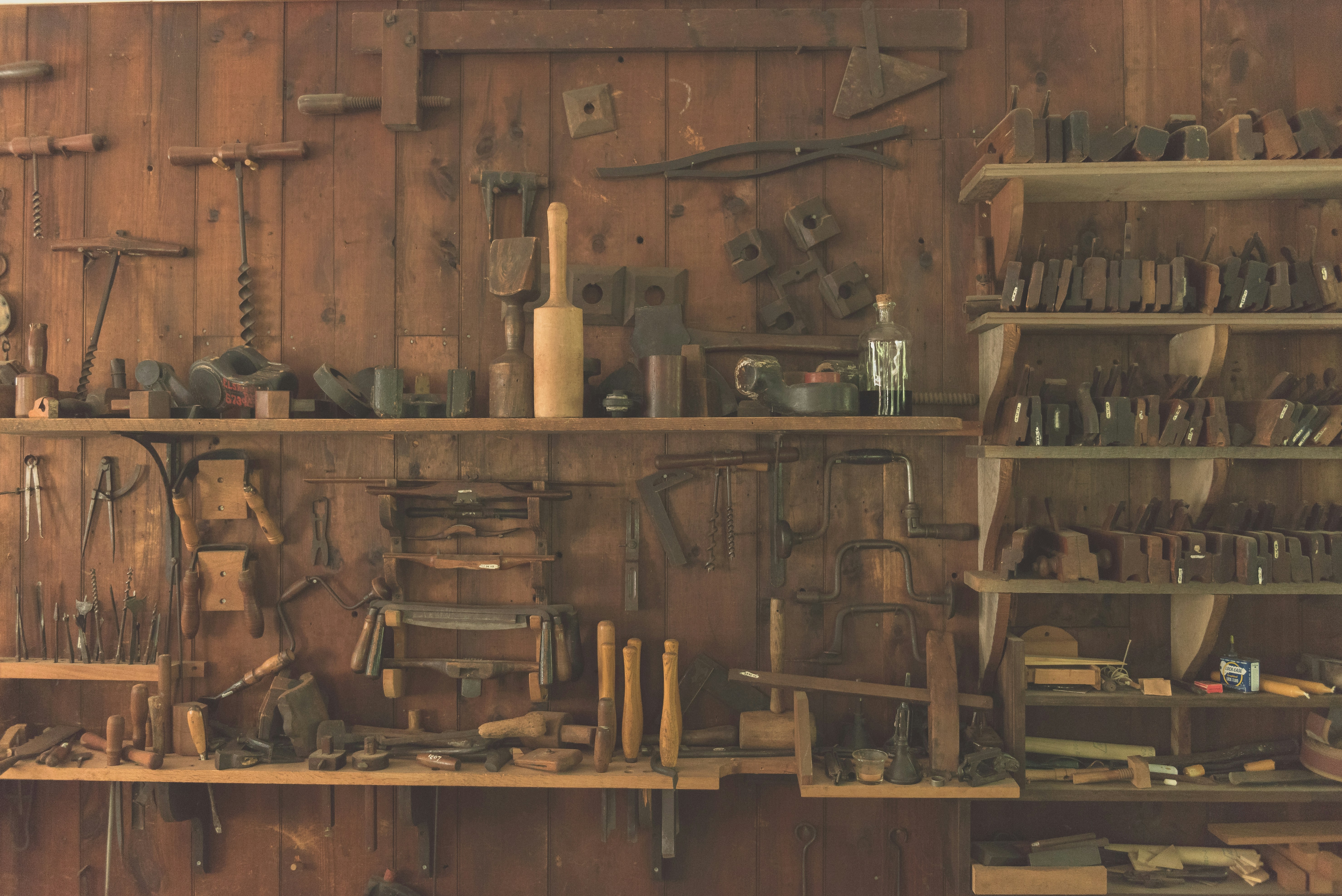 Old carpentry workshop with hand tools hanging on a wooden wall
