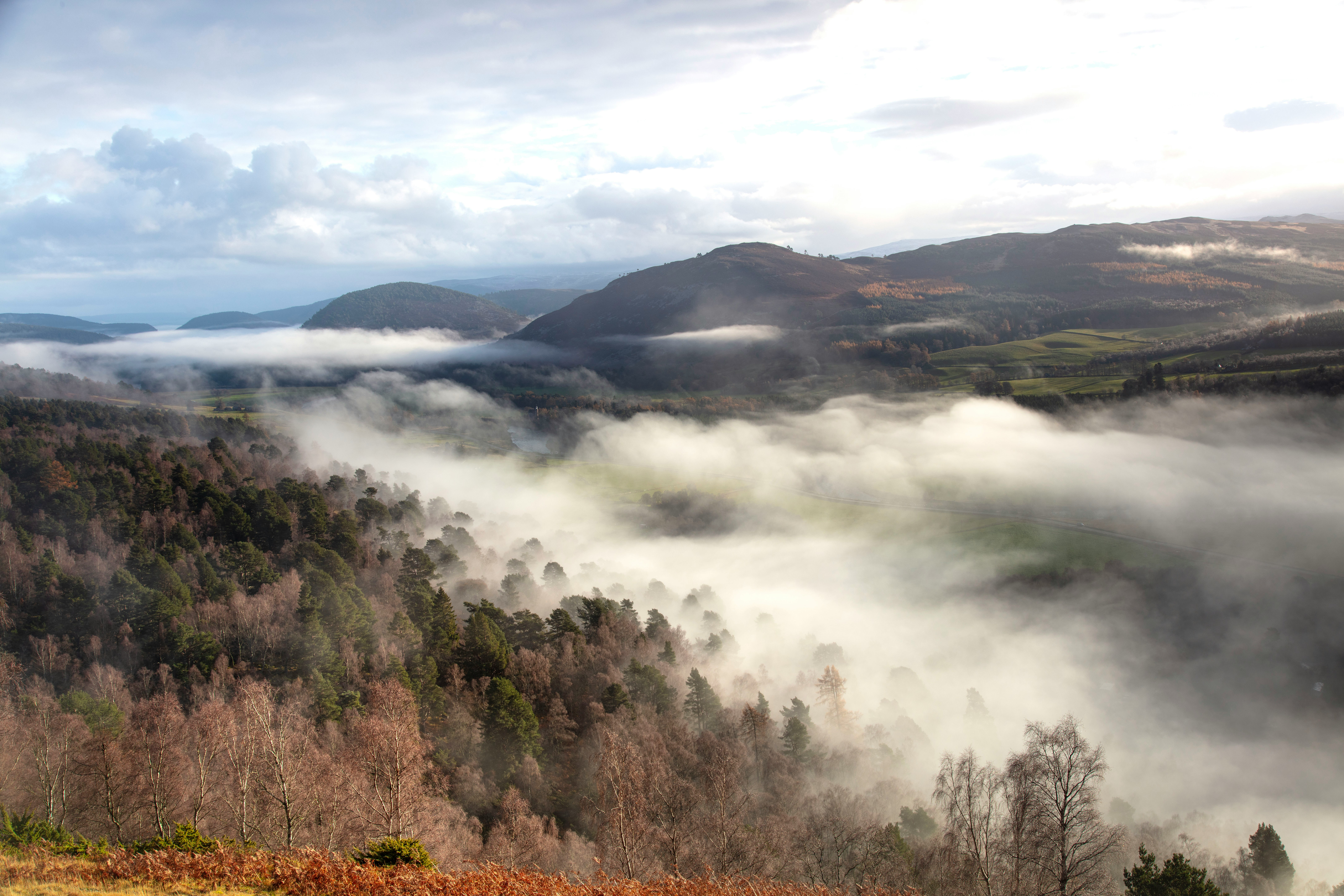 Misty Scottish highland landscape with winding path through moorland