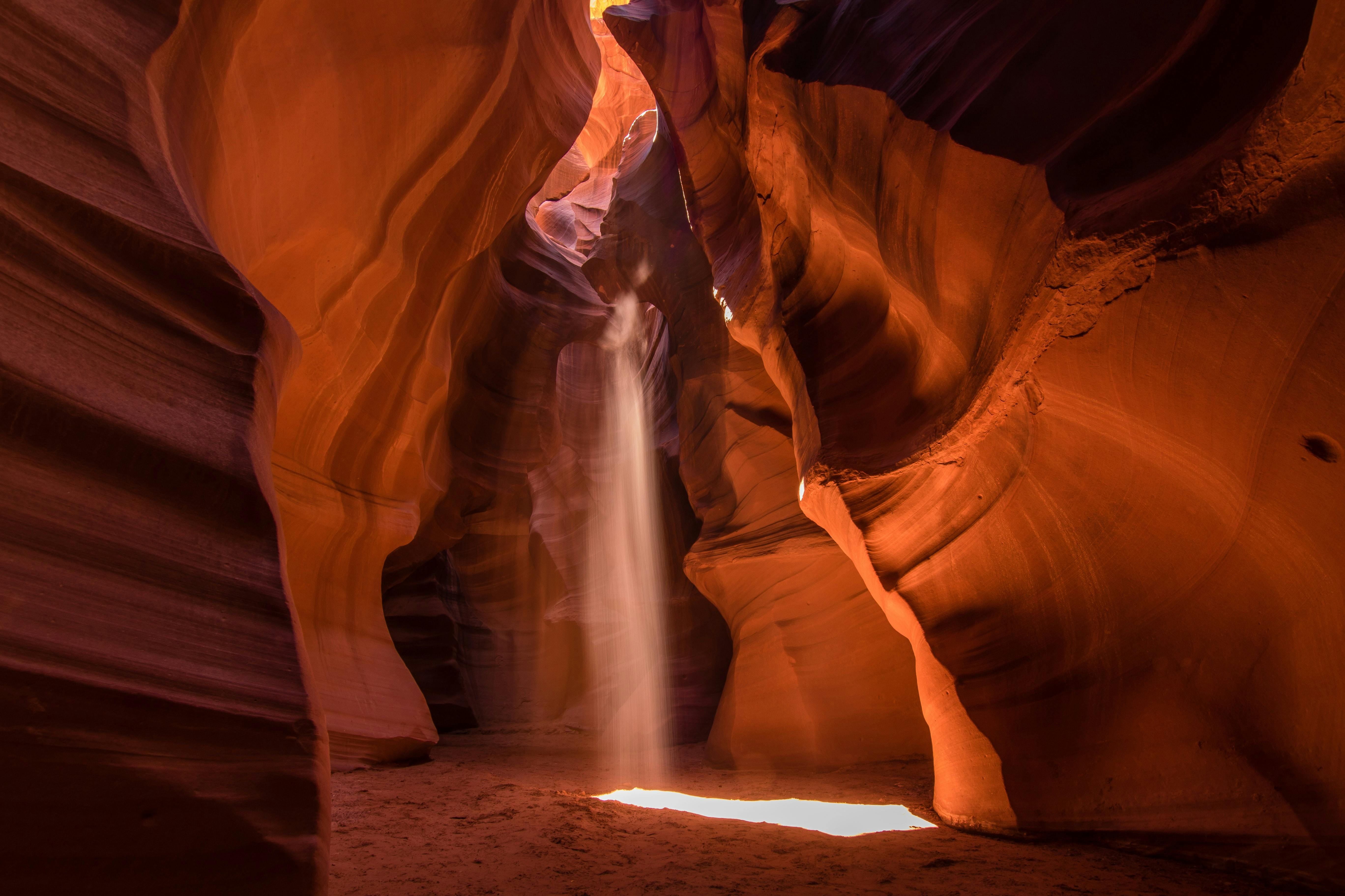 Sunlight beam piercing through layered sandstone walls of Antelope Canyon, Arizona